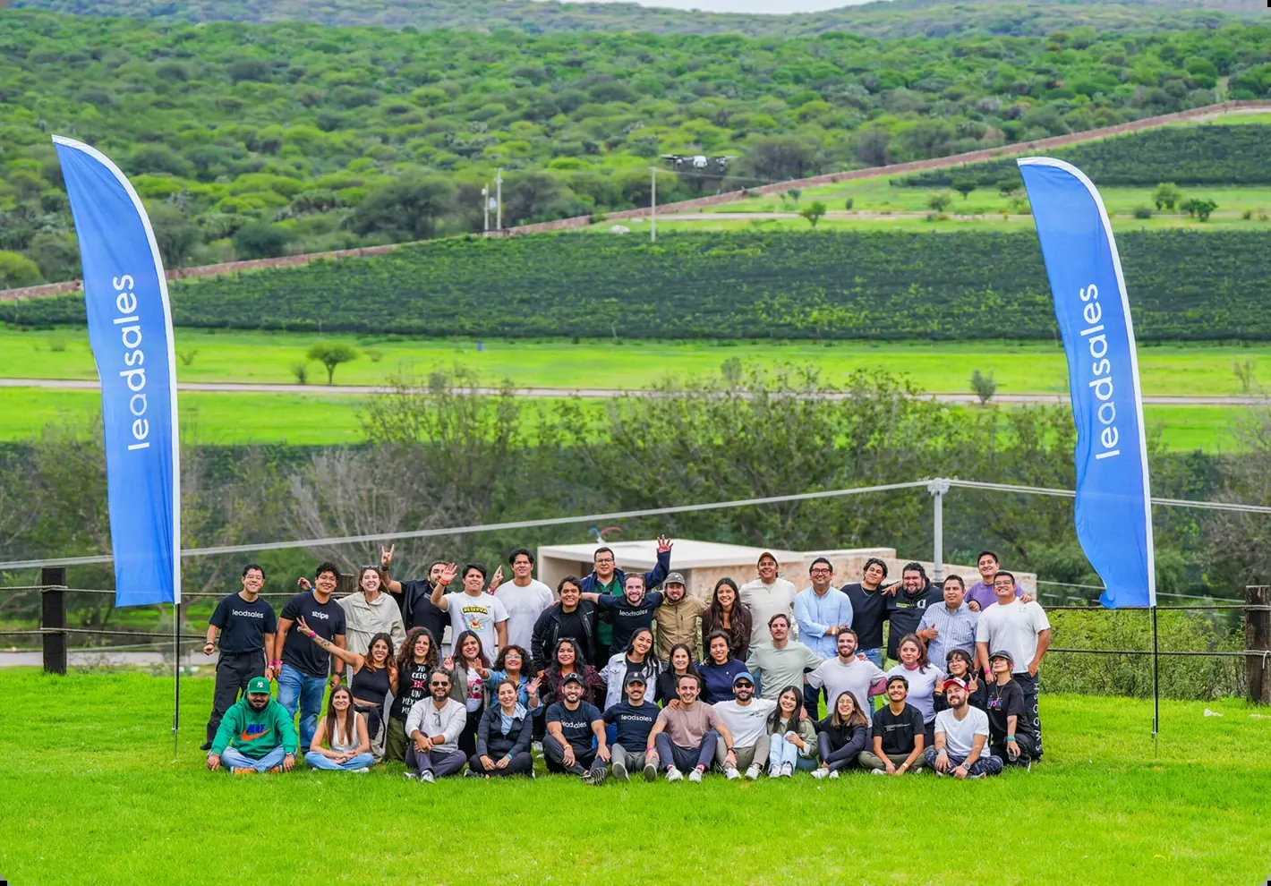 The Leadsales team in a garden between two Leadsales flags