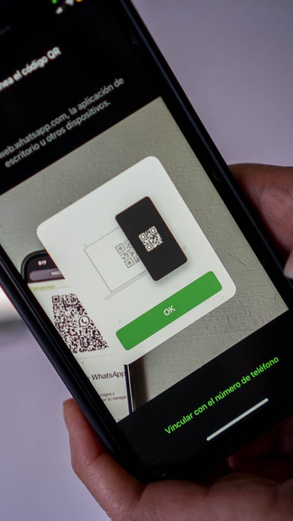Fotografía que muestra la pantalla de un teléfono celular en la cual se está escaneando el código QR para ingresar a WhatsApp Web